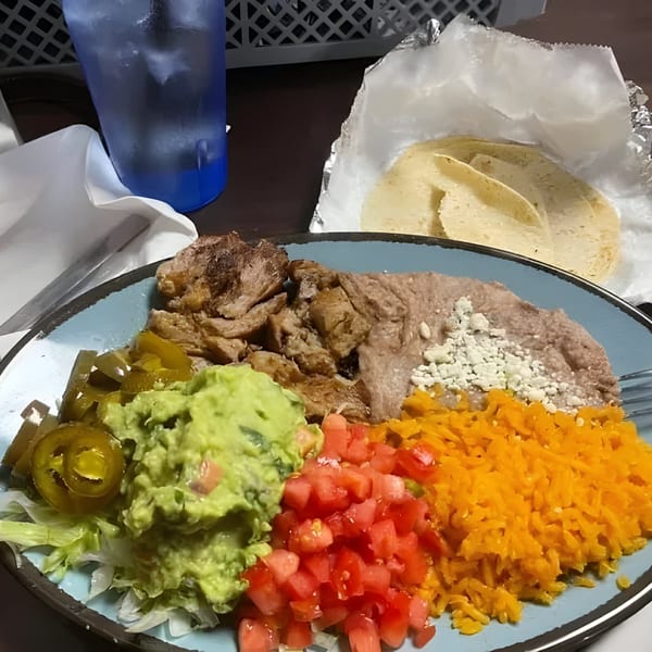 La Familia Cafe's Mexican dish with meat, refried beans, rice, guacamole, diced tomatoes, and jalapeños.